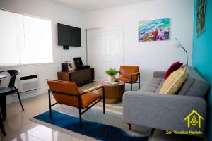 sala de estar con sofá y 2 sillas en BH Club By Zen Vacation Rentals, en Miami Beach