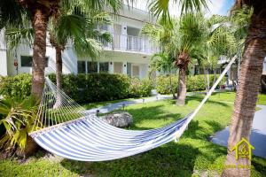 a hammock in a yard with palm trees at BH Club By Zen Vacation Rentals in Miami Beach