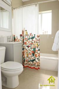 a bathroom with a toilet and a shower curtain at BH Club By Zen Vacation Rentals in Miami Beach