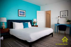 a bedroom with a large bed with a blue wall at BH Club by Zen Vacation Rentals 2BR 1BA in Miami Beach