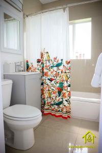 a bathroom with a toilet and a shower curtain at BH Club by Zen Vacation Rentals 2BR 1BA in Miami Beach