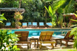 a group of chairs sitting next to a swimming pool at Rabbit Resort Pattaya in Pattaya South