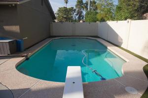 een zwembad in een achtertuin met een hek bij 3bdr Remodeled Scottsdale Desert Pool Oasis and Entertainment in Phoenix