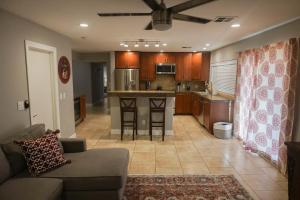 a living room with a couch and a kitchen at 3bdr Remodeled Scottsdale Desert Pool Oasis and Entertainment in Phoenix