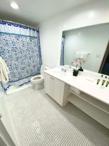 Un baño con lavabo, inodoro y espejo. en Oversized 2-Bedroom on the Ocean, en Hollywood