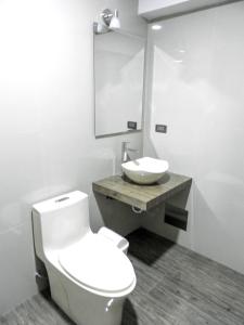 een badkamer met een wit toilet en een wastafel bij Hotel Cumbre Real Airport - Arequipa in Arequipa