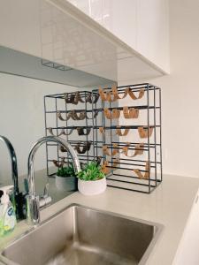 a kitchen counter with a sink and a rack of shoes at Cosy and Stylish 1 BD Serviced Apt at SouthBank in Brisbane