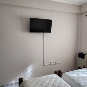Habitación con 2 camas y TV de pantalla plana en la pared. en La constancia en La Plata