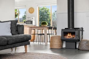 a living room with a fireplace and a couch at Ebb and Flow Torquay pet friendly unit in Torquay