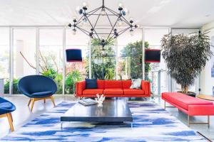 sala de estar con sofá rojo y sillas azules en Increíble departamento en Santa Fe con gym, alberca y estacionamiento, en Ciudad de México