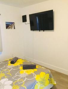 a bedroom with a bed with a flat screen tv on the wall at Home Sweet Home in Miami