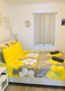 a bedroom with a bed with a yellow and white blanket at Home Sweet Home in Miami