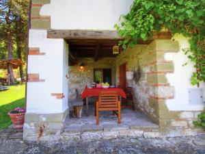Castel FocognanoにあるModish Farmhouse in Ortignano with Swimming Poolの石造りの建物内の屋外パティオ(赤いテーブル付)