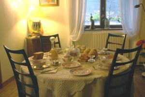 a dining table with a white table cloth and food on it at Les Etangs de Pitié in Mellionnec
