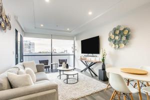 a living room with a couch and a table at Modern 2BR Apartment near Wollongong Beach in Wollongong