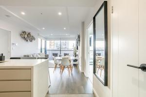 eine Küche und ein Wohnzimmer mit einem Tisch und Stühlen in der Unterkunft Modern 2BR Apartment near Wollongong Beach in Wollongong