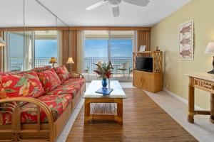 a living room with a couch and a television at Beautiful Oceanfront Condo! - Hale Kona Kai 303 in Kailua-Kona