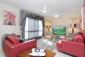 a living room with two red couches and a tv at Vibrant, Lovely 3BR Family Home in North Ward