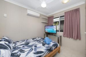 a bedroom with a bed and a flat screen tv at Vibrant, Lovely 3BR Family Home in North Ward