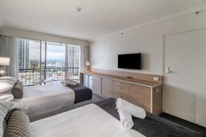 a bedroom with two beds and a flat screen tv at Gorgeous Private Suite with Balcony in Gold Coast