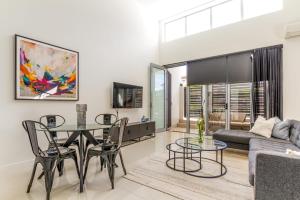 uma sala de estar com uma mesa e cadeiras e um sofá em Luxurious 3BDR Townhouse in Great Location em Brisbane