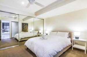 1 dormitorio con 1 cama blanca grande y espejo en Luxurious 3BDR Townhouse in Great Location en Brisbane