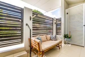 einen Balkon mit einer Bank und einem Fenster mit Jalousien in der Unterkunft Luxurious 3BDR Townhouse in Great Location in Brisbane