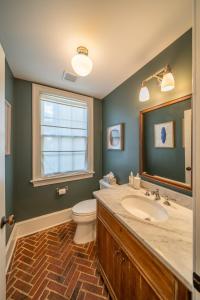 a bathroom with a sink and a toilet and a window at The Walton House - historic 3bd 2 5ba with parking in Kennett Square