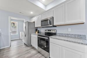 a kitchen with white cabinets and a stove top oven at Endless Summer condo in Branson West