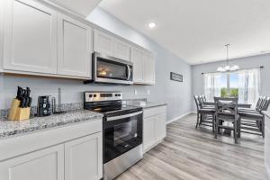 a kitchen with white cabinets and a stove top oven at Endless Summer condo in Branson West