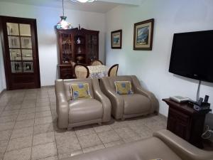 Il comprend un salon doté d'un canapé et d'une télévision à écran plat. dans l'établissement Casa de Praia Ibicuí, à Mangaratiba