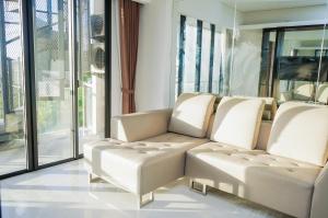 una sala de estar con muebles blancos y ventanas grandes. en Nusa Dua Penthouse en Nusa Dua