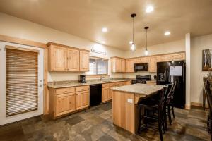 a kitchen with wooden cabinets and a island with a counter top at Luxury Mountain Home w Pool & Private Hot Tub in Park City