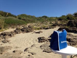 una borsa blu seduta su una sedia in spiaggia di Cinquestelle Albergo del centro storico a Palinuro
