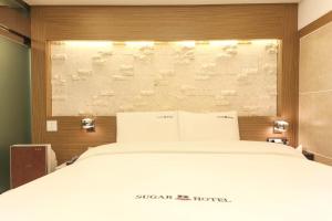 Postel nebo postele na pokoji v ubytování Sugar Hotel