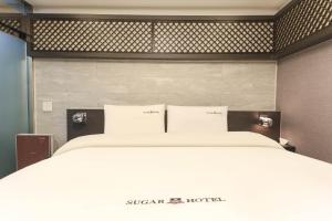 Postel nebo postele na pokoji v ubytování Sugar Hotel
