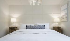 1 dormitorio blanco con 1 cama grande y 2 lámparas en Shoreline Hideaway, en Tootgarook