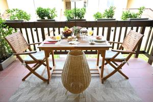 un tavolo in legno e 2 sedie su un patio di AURA loving home con 4 posti letto, terrazzo, cucina e grande parco circostante a Serravalle dʼAsti
