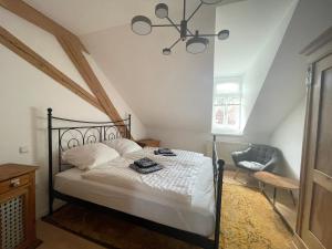 a bedroom with a bed with white sheets and a chandelier at Haardter Mandelring in Neustadt an der Weinstraße