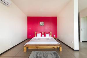 a bedroom with a bed in a red wall at Le Panorama in Cilaos
