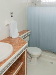 a bathroom with a white toilet and a sink at Casa Toboro in Taganga
