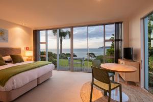 a bedroom with a bed and a view of the ocean at Cable Bay Surf Studio in Cable Bay