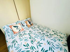 - un lit avec 2 oreillers et des feuilles dans l'établissement 1BR @ Grace Taguig near NAIA & BGC, à Manille