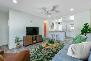 sala de estar con sofá azul y TV en Paradise Palms- Tropic Suite- Pool - Steps to Ocean - 10 min to Downtown en Saint Augustine