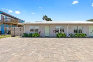 a house with a brick driveway in front of it at Paradise Palms- Tropic Suite- Pool - Steps to Ocean - 10 min to Downtown in Saint Augustine