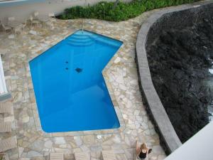 カイルア・コナにあるOceanfront Condo to Enjoy Sea Breeze and Sunset on Lanai which hangs over the ocean!! - Hale Kona Kai 305の石造りの通路付きのスイミングプールの上面の景色 +11枚の写真