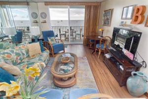 カイルア・コナにあるOceanfront Condo to Enjoy Sea Breeze and Sunset on Lanai which hangs over the ocean!! - Hale Kona Kai 305のリビングルーム(ソファ、テレビ付)が備わります。