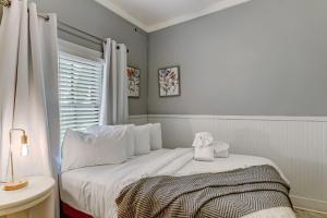 een witte slaapkamer met een bed en een raam bij 130 Y O Historic Savannah Cottage off Forsyth Park in Savannah
