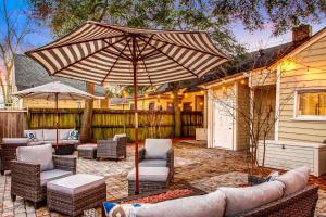 een patio met stoelen en een parasol bij 130 Y O Historic Savannah Cottage off Forsyth Park in Savannah