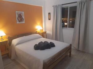 a bedroom with a bed with two hats on it at Depto Rawson Home in Rawson